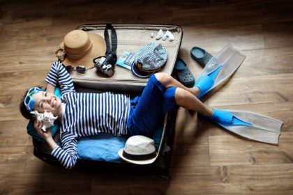 boy and suitcase .suitcase folded on vacation. planned trip to the sea.flat lay travel