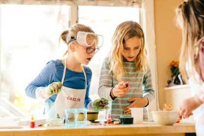 Three surprised girls doing science experiment, staring